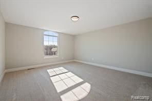 carpeted spare room with baseboards