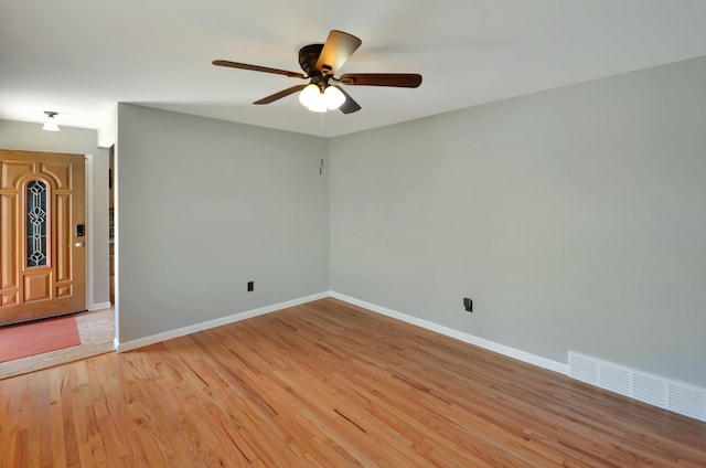 empty room featuring visible vents, baseboards, light wood finished floors, and ceiling fan