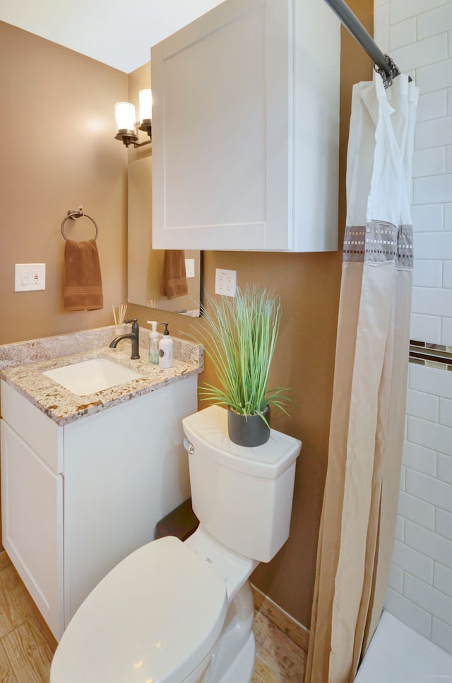 full bath with vanity, toilet, and tiled shower