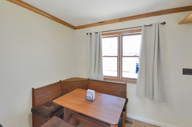 dining area featuring visible vents, wood finished floors, baseboards, and ornamental molding