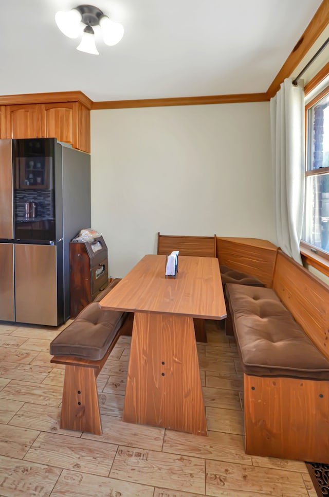 dining area featuring breakfast area, light wood-type flooring, and crown molding