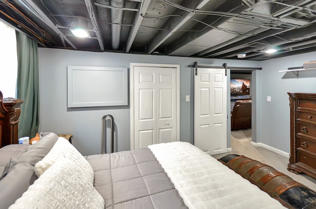 bedroom featuring a barn door, carpet, and a closet