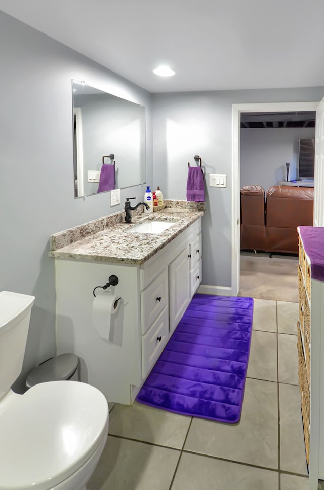 bathroom featuring tile patterned floors, baseboards, toilet, and vanity