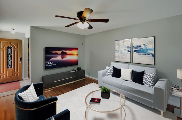 living area featuring baseboards, a ceiling fan, and wood finished floors