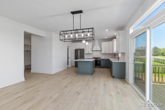 8123 Byron Depot Dr SW, Byron Center, MI 49315 - kitchen featuring appliances with stainless steel finishes, custom range hood, a sink, a center island, and light countertops