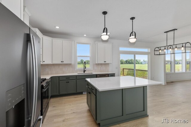 8123 Byron Depot Dr SW, Byron Center, MI 49315 - kitchen featuring stainless steel fridge, a sink, white cabinets, light countertops, and light wood-style floors
