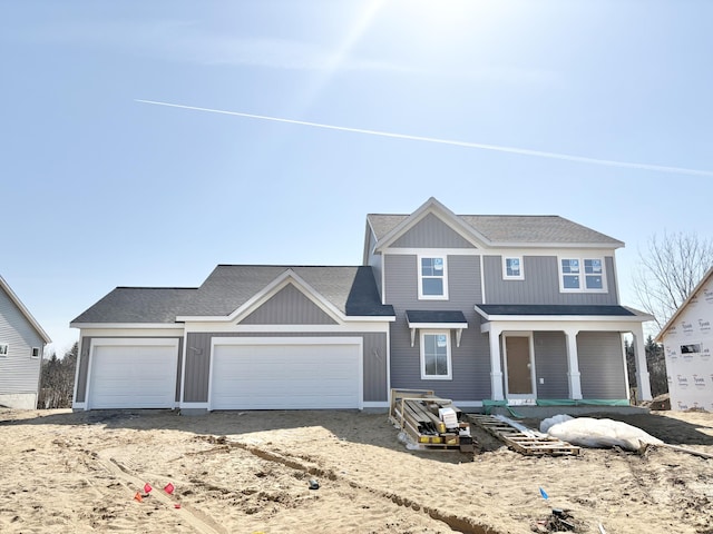 view of front of property featuring a garage, driveway, and roof with shingles