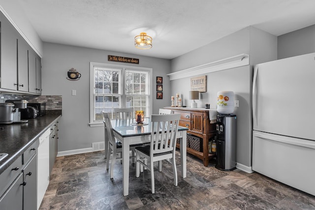 dining room with stone finish flooring, visible vents, and baseboards