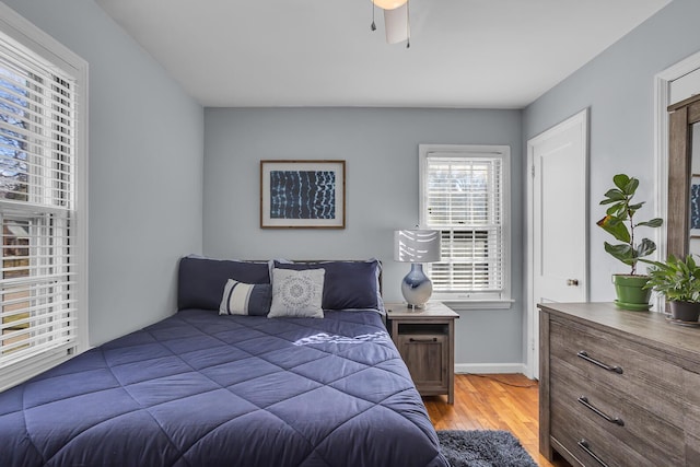 bedroom featuring light wood finished floors and baseboards