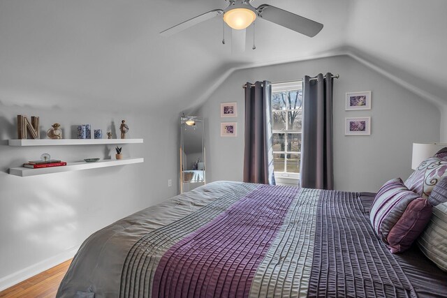 bedroom featuring a ceiling fan, vaulted ceiling, and wood finished floors