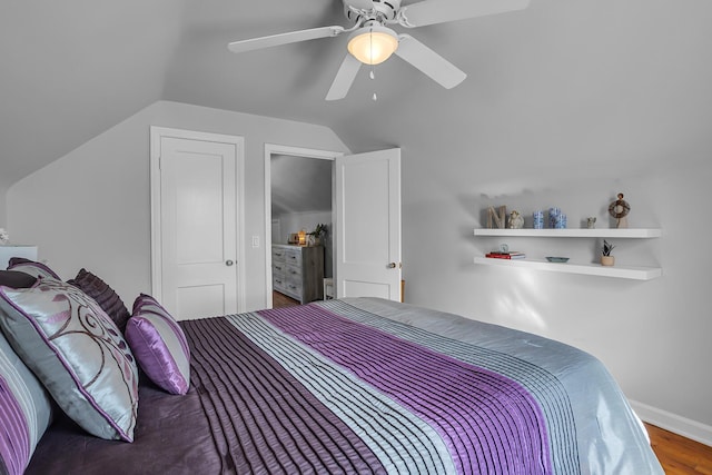 bedroom with lofted ceiling, ceiling fan, baseboards, and wood finished floors