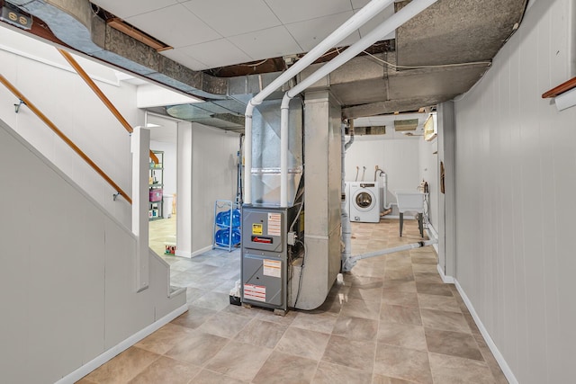 unfinished below grade area featuring independent washer and dryer, a sink, heating unit, and stairs