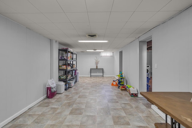 finished below grade area featuring a paneled ceiling and visible vents