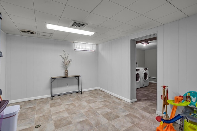 basement featuring separate washer and dryer, a paneled ceiling, visible vents, and baseboards