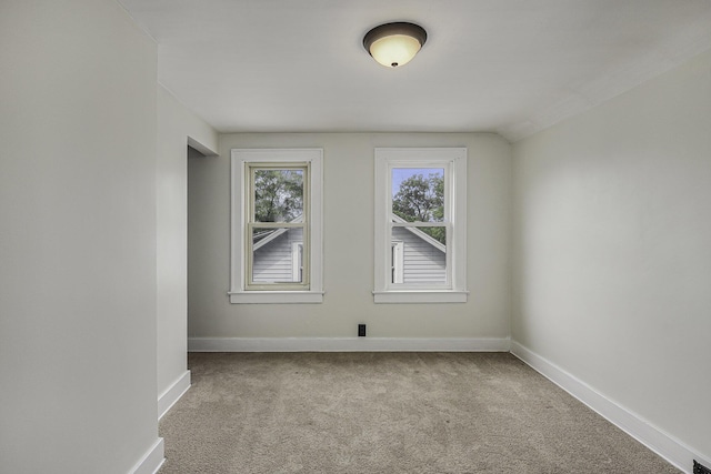 carpeted empty room featuring baseboards