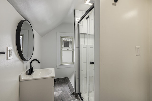 bathroom with vaulted ceiling, a stall shower, vanity, and baseboards