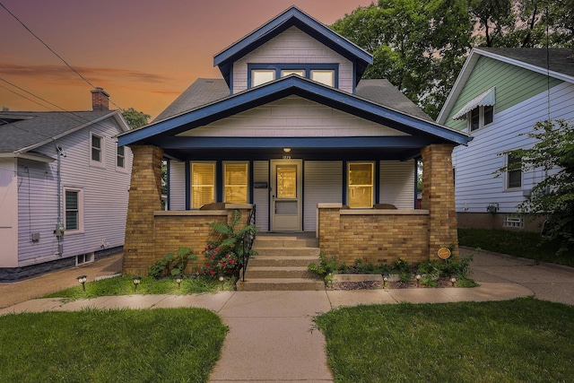 view of front of house featuring a porch and brick siding