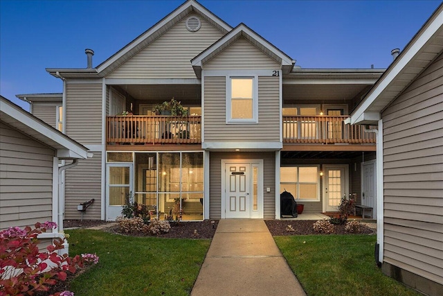 exterior space featuring a front lawn and a balcony