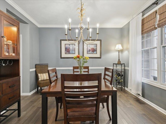 dining room with a chandelier, dark wood-style flooring, crown molding, and baseboards