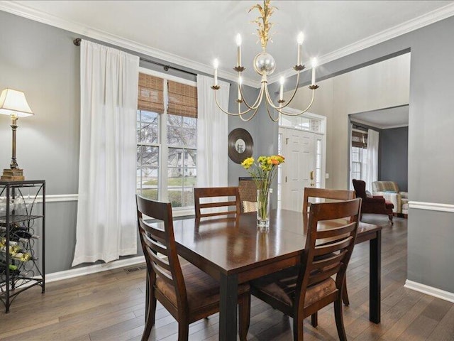 dining area with wood-type flooring, baseboards, and crown molding