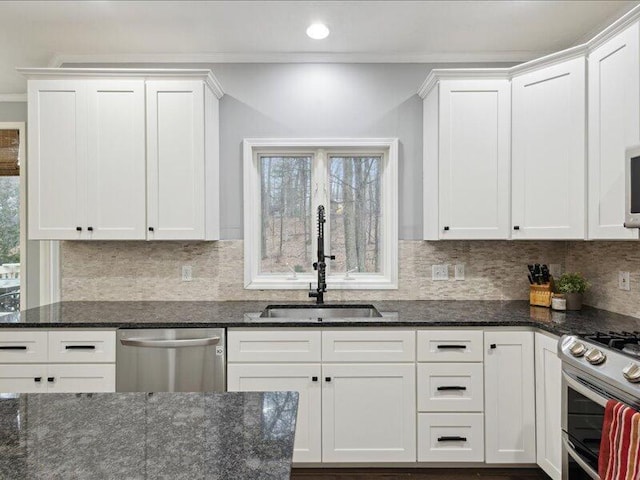 kitchen with a wealth of natural light, tasteful backsplash, appliances with stainless steel finishes, and a sink