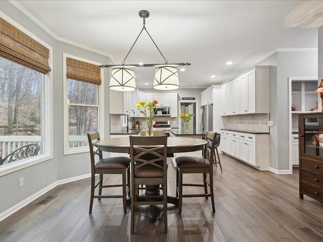 dining area with baseboards, dark wood finished floors, visible vents, and crown molding