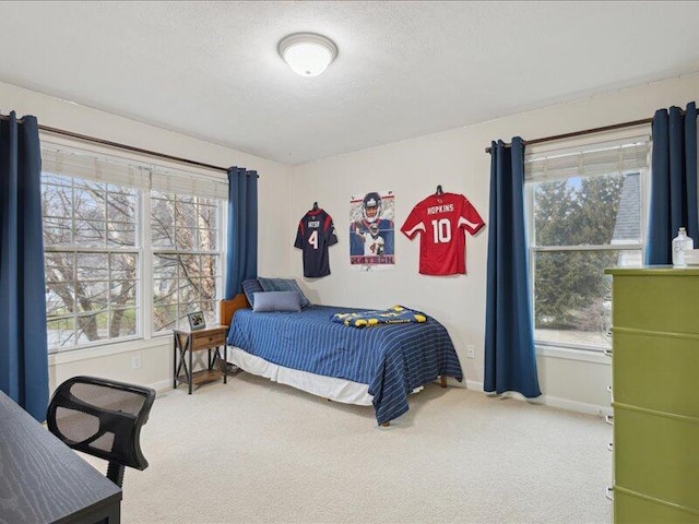 bedroom featuring a textured ceiling, carpet, and baseboards