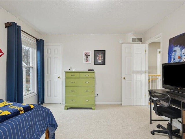 bedroom with baseboards, a textured ceiling, visible vents, and light colored carpet