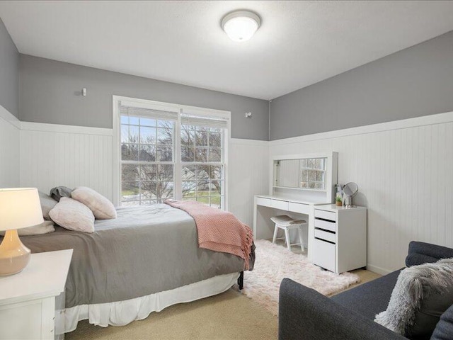 bedroom with carpet and wainscoting