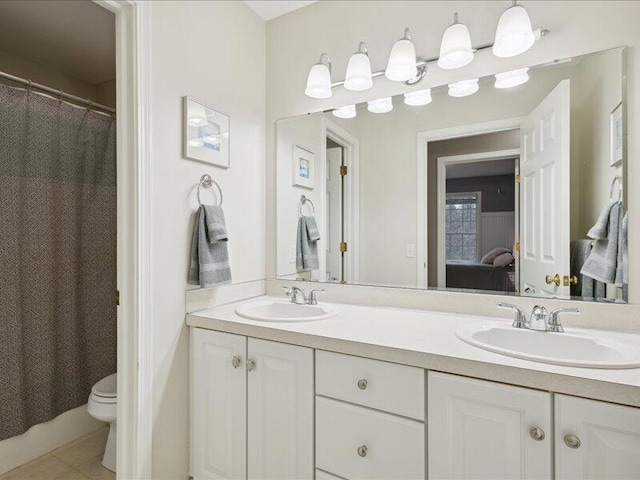 ensuite bathroom with double vanity, ensuite bath, toilet, and a sink