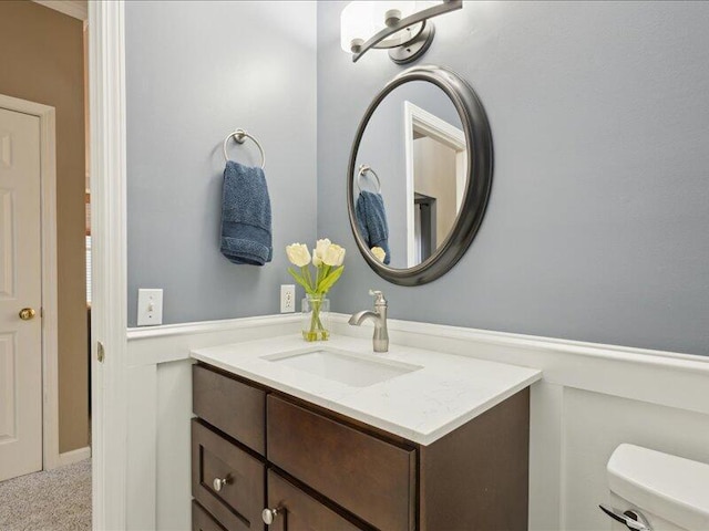 half bathroom with vanity and toilet