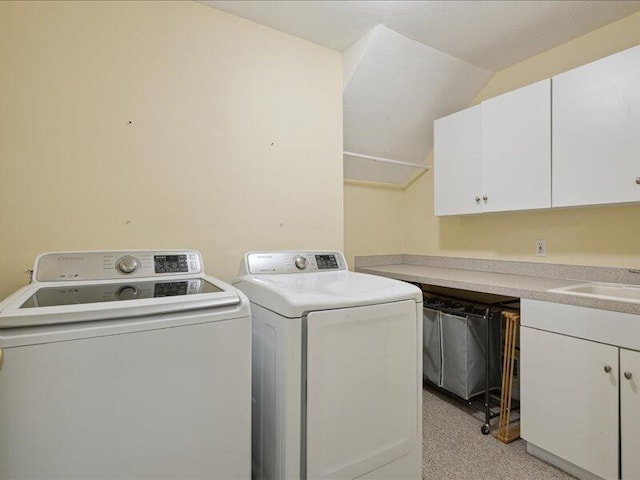 laundry area featuring cabinet space, a sink, and washing machine and clothes dryer