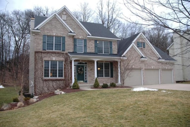 view of front of home featuring an attached garage, brick siding, driveway, a front lawn, and a chimney