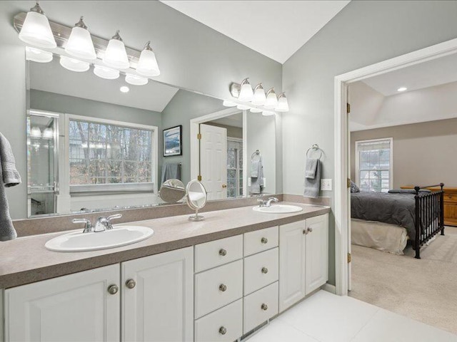 ensuite bathroom with lofted ceiling, ensuite bath, double vanity, and a sink