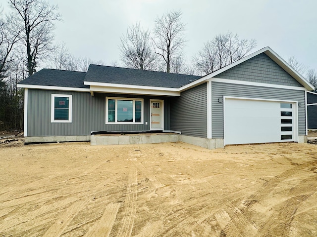 view of front of home with roof with shingles, driveway, and an attached garage