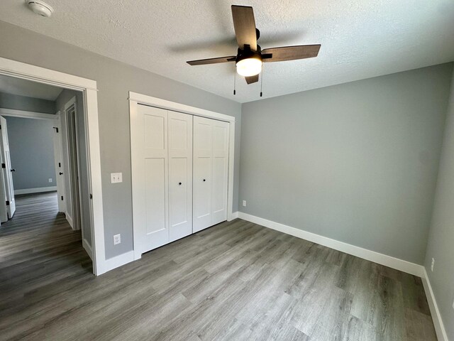 2653 Mclaughlin Ave, Muskegon, MI 49442 - unfurnished bedroom featuring baseboards, a textured ceiling, wood finished floors, and a closet