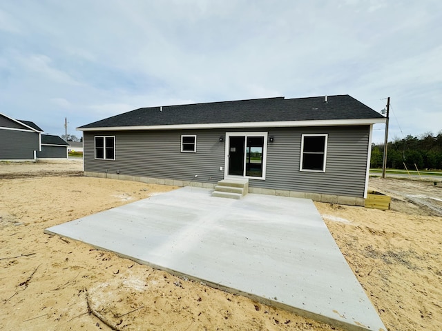 2653 Mclaughlin Ave, Muskegon, MI 49442 - back of property with a shingled roof, a patio area, and entry steps