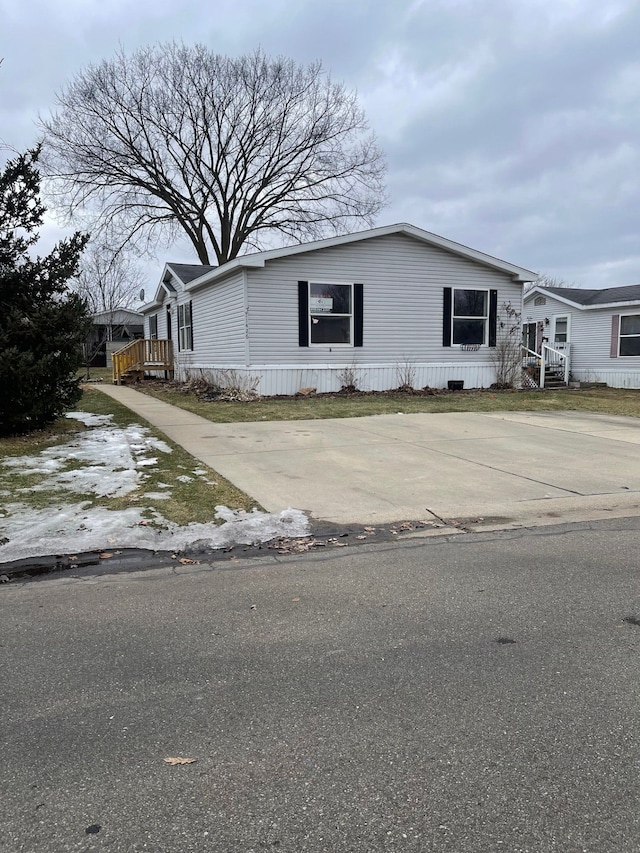 manufactured / mobile home featuring concrete driveway