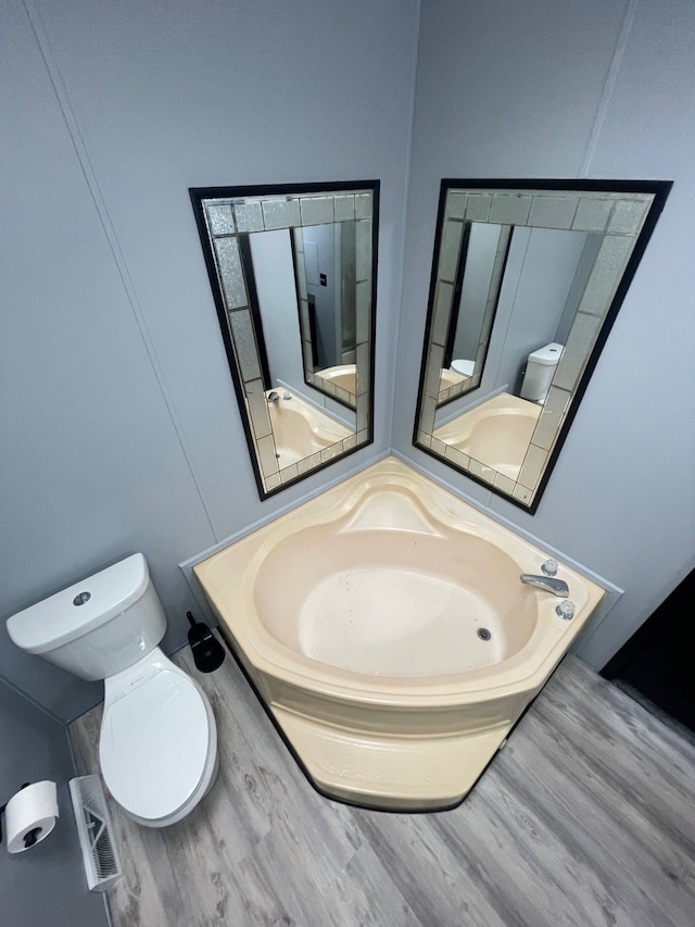 bathroom featuring visible vents, wood finished floors, and toilet