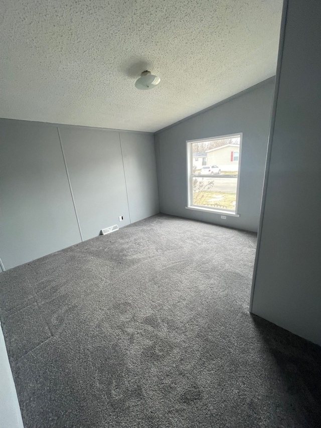 carpeted empty room with a textured ceiling and visible vents