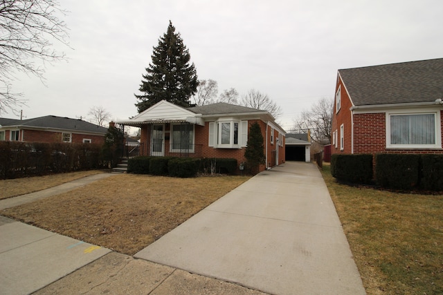 bungalow-style home with a front yard, brick siding, and an outbuilding