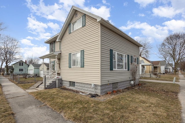 view of side of home with a yard and fence