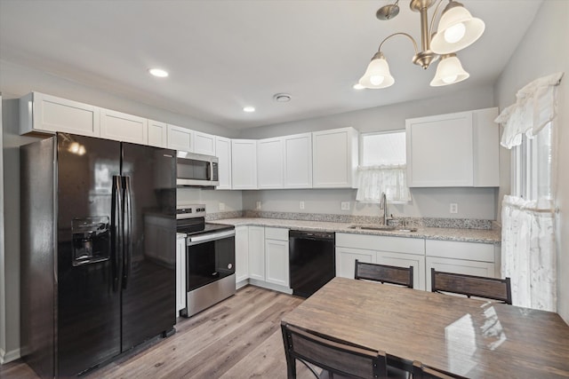 kitchen featuring white cabinetry, a sink, and black appliances