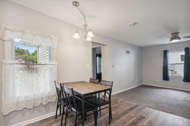 dining area featuring dark wood-style floors, plenty of natural light, visible vents, and baseboards