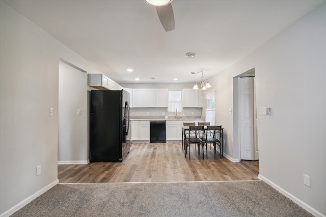 kitchen featuring black appliances, light countertops, white cabinetry, and baseboards