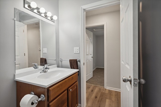 bathroom with baseboards, wood finished floors, and vanity