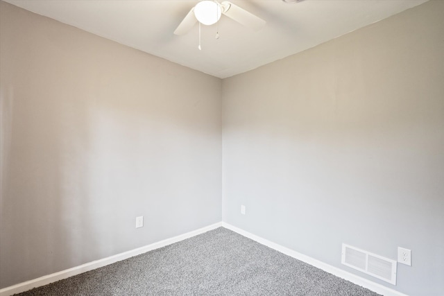 carpeted empty room featuring baseboards, visible vents, and a ceiling fan