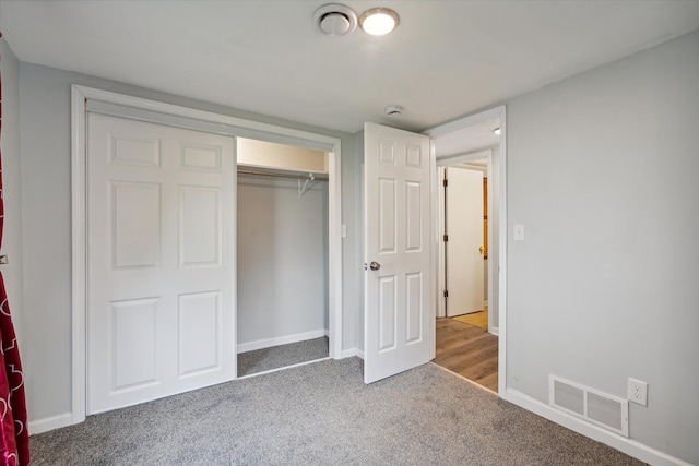 unfurnished bedroom featuring carpet, visible vents, and baseboards