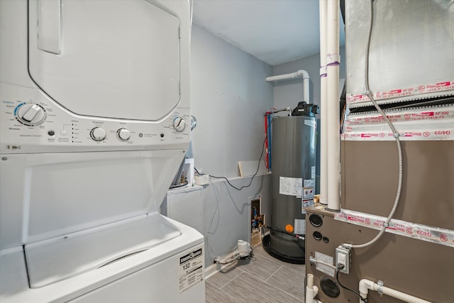 laundry room with water heater, stacked washer and dryer, laundry area, and heating unit