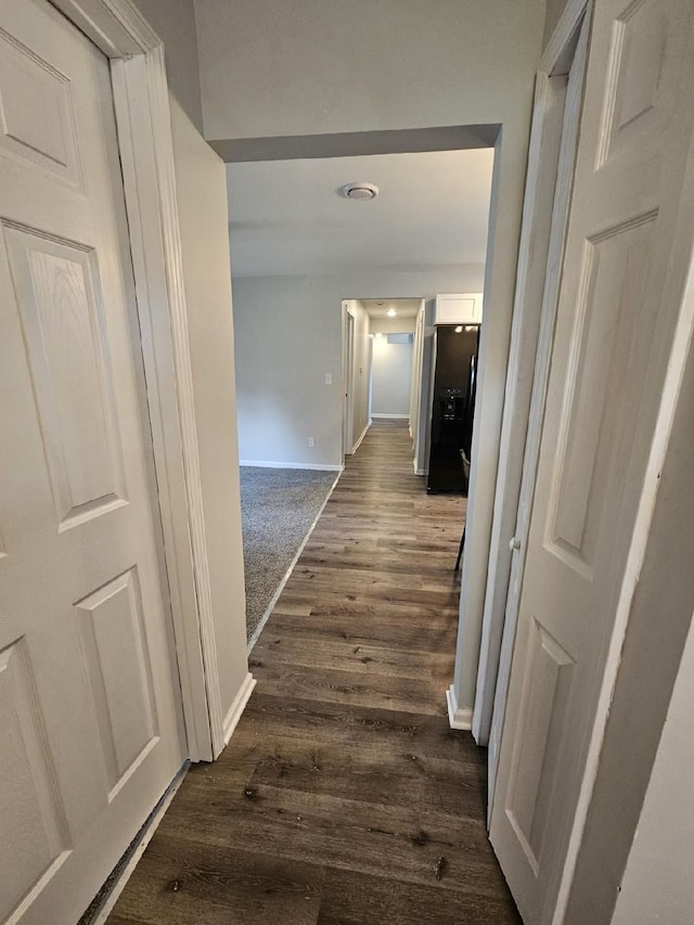 hall with dark wood-style floors and baseboards